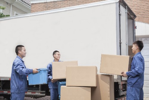 Moving team handling office furniture in a Chelsea street