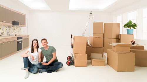 Movers carrying furniture down stairs during Chelsea flat removal